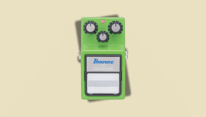 Ibanez TS-9 Tube Screamer pedal with its iconic green housing and three-knob layout for Drive, Tone, and Level, delivering the warm midrange boost used for solo passages and tonal coloration.