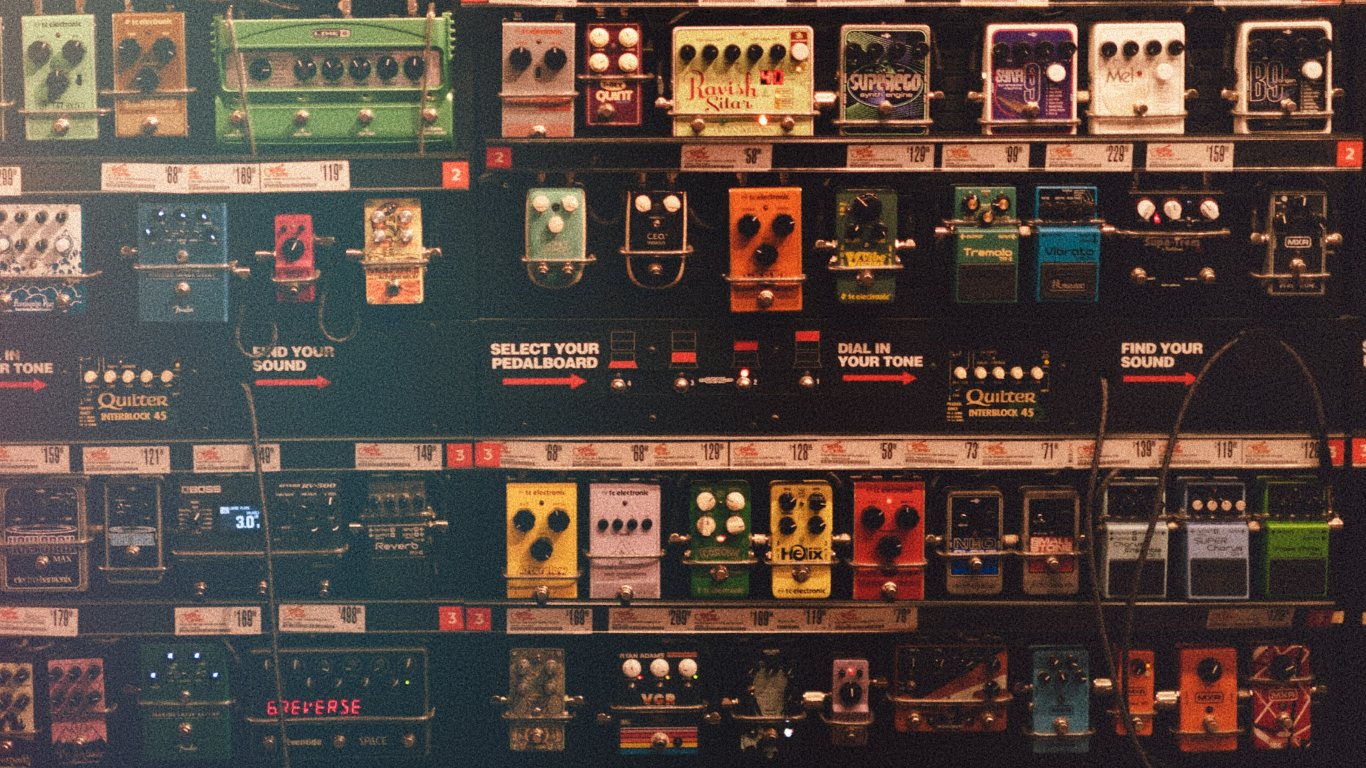 A wall of guitar effects pedals stretching into the distance