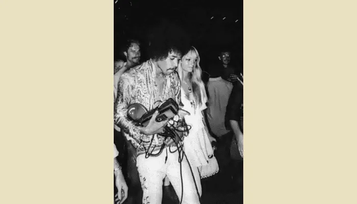 Jimi Hendrix holding his Dallas Arbiter Fuzz Face pedal, the germanium fuzz unit central to his iconic guitar tone.