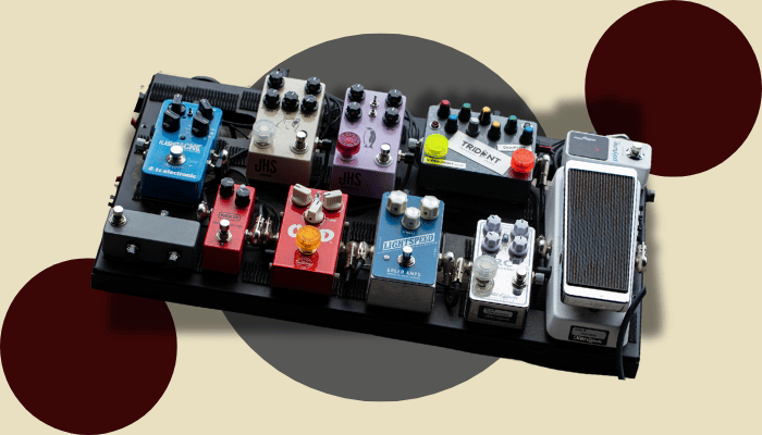 A fully loaded guitar pedalboard featuring effects from JHS, Walrus Audio, and other brands, including overdrive, delay, modulation, and a volume pedal, neatly arranged on a black board.