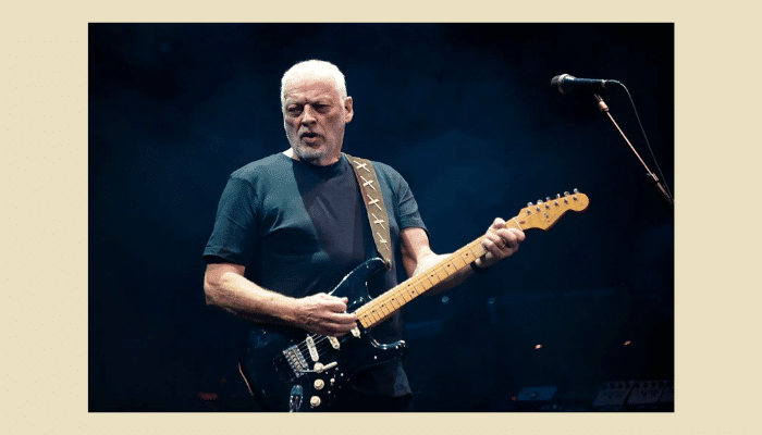Guitar Delay Pedals: How They Work, Types & Setup Guide 11 David Gilmour from Pink Floyd performing live with black Fender Stratocaster guitar, wearing black shirt against dark stage backdrop