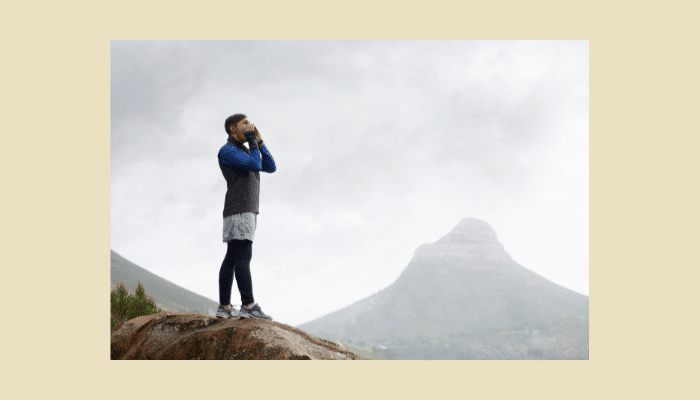 Guitar Delay Pedals: How They Work, Types & Setup Guide 1 Person shouting into mountain canyon demonstrating natural echo effect that guitar delay pedals recreate.