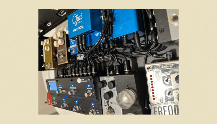 Neatly organized guitar pedalboard with tidy cable management and multiple effects pedals.